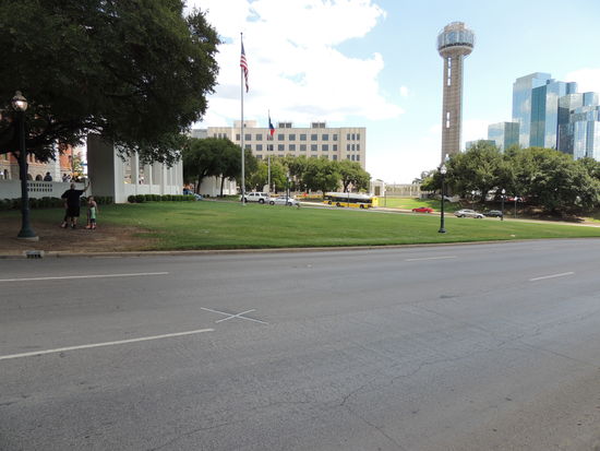 Auf der Straße das Kreuz markiert die Stelle des Attentates.