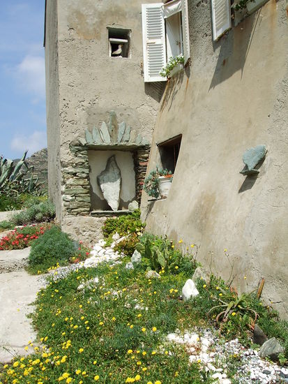 Steine in Herzform und in Form des Inselumrisses schmücken dieses Haus in Centuri Port