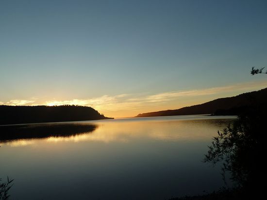Wunderschoen der spiegelglatte Lago Huillinco im Sonnenuntergang.