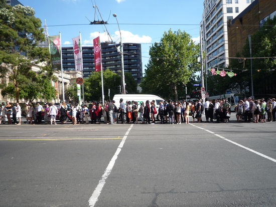 Zivilisiert sich für das Einsteigen in die Straßenbahn einreihende Australier