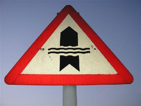 Dieses Schild macht darauf aufmerksam, dass es passieren könnte, dass das Wadi, wenn es Wasser führt, die Straße überfluten könnte