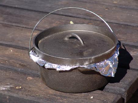 Kleide den Camp Oven mit Aluminiumfolie aus. Etwas Öl darin verteilen verhindert allzu festes kleben der Folie am Brot.