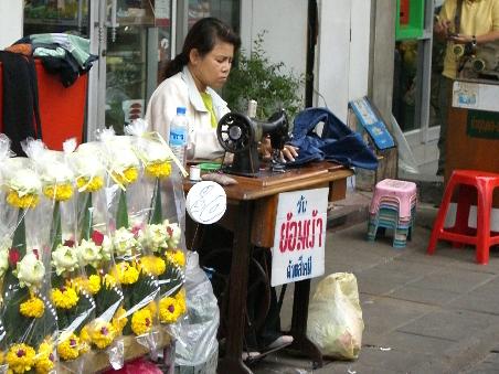 Ab und an sieht man Schneiderinnen auf der Strasse arbeiten, auch einige Schuster. Das Leben der Thais spielt sich meist auf der Strasse ab.
