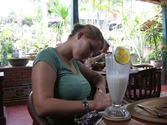 Sarah mit Milkshake am Karten schreiben.