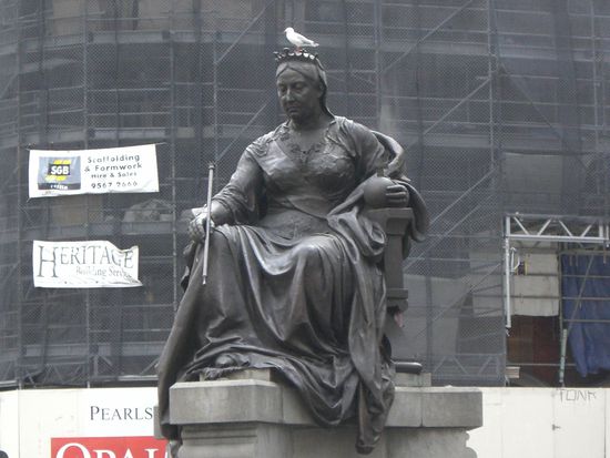 Eine Taube sitzt auf dem Kopf von Queen Victoria.