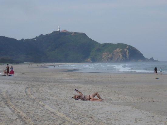 Strand mit Leuchtturm im Hintergrund.