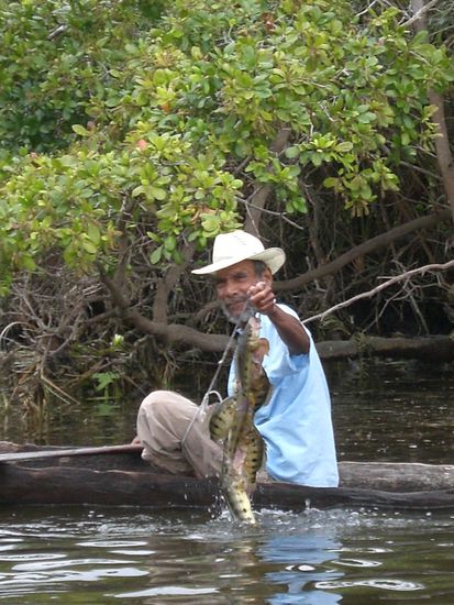 Fischer in einfachem Holzkanu.