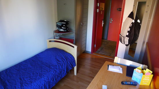 ..ein einfaches Bett mit Holzbret statt Lattenrost, ein Tisch, ein Stuhl, ein Spind...und das Bett muss man selber beziehen...