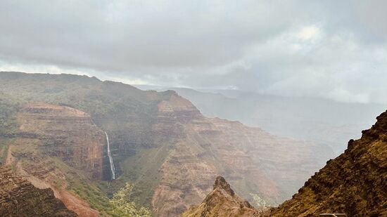 Leider regnet es immer wieder. Je höher wir kommen, desto nebliger wird es. Noch können wir den Wasserfall des Weimea Canyon erkennen.