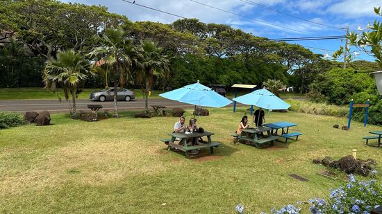 Trotz Regen sitzen die Gäste im Freien. Einige der Tische sind mit Schirm ausgestattet.