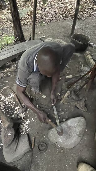 …während der Schmied das Stahl erhitzt und bearbeitet