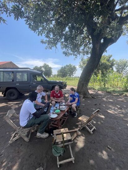 Jetzt bekommen wir erstmal was zu essen: gekochtes Huhn im Schatten unter einem der Bäume—es hat aufgehört zu regnen und es wird schwülwarm