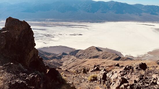 Wir blicken auf riesige Salzflächen des „Bad Water Basin“ aber auch auf die weite felsige Umgebung