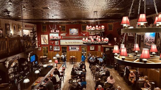 Wir bekommen einen Tisch im oberen Stock mit Blick hinab in den Saloon
