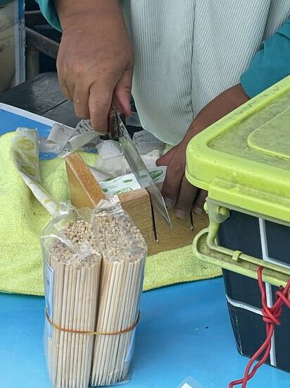 Die Dame schneidet die Blöcke in Würfel—dabei misst sie die Größe genau an den gefrästen Nuten ab…