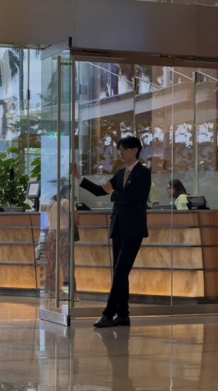 Thomas beobachtet eine ganze Weile diesen jungen TürBoy. Immer wenn Gäste kommen, hat er die Tür zu öffnen. Das ist wohl ein sehr langweiliger Job—lange Zeit kommen keine Gäste, aber er öffnet und schließt die Tür trotzdem und träumt dabei vor sich hin 