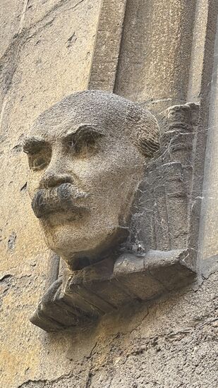 Am Eingang der geschnitzte Steinkopf mit dem amüsanten Titel: Grimme Entschlossenheit angesichts des Dienstag Morgens