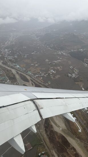 Es ist neblig, fast eine Stunde kreisen wir über Paro-dann drehen wir ab nach…