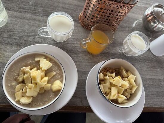 Zum Frühstück gibt es Porridge und Müsli mit Obst und Milch.