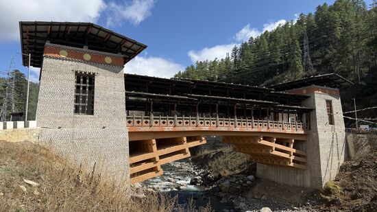 Es handelt sich um die 35 Meter lange  „Pangrizampa Brücke“ , die erste motorisierte traditionelle überdachte Brücke. Sie verbindet die traditionelle bhutanische Architektur mit moderner Ingenieurskunst