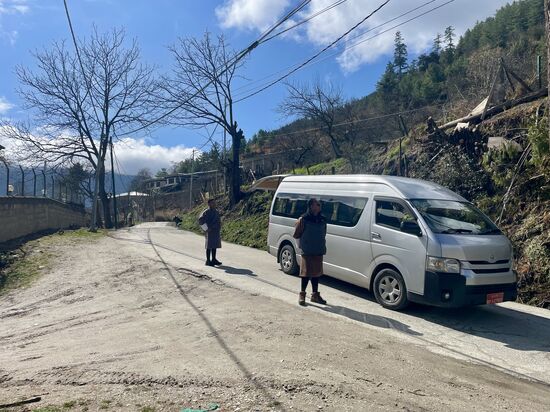 Unser Guide Som und unser Fahrer Phurpa sind in traditioneller Kleidung und mit Trecking-Schuhen bekleidet
