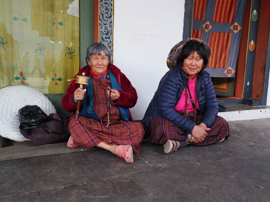 Manche mit kleiner Gebetsmühle und Gebetskette in der Hand