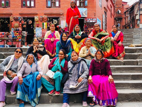 Die Anlage befindet sich auf einem Hügel und wir gehen die Treppen hinauf—Thomas macht hier Aufnahmen von einer Gruppe Frauen die bunt gekleidet sind