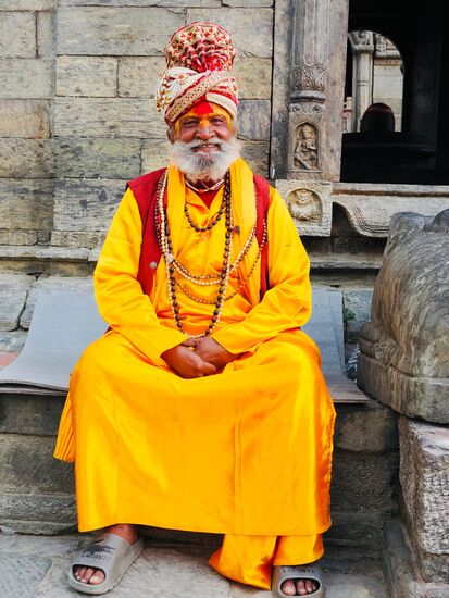 Sie tragen typischerweise senfgelbe oder orangefarbene Kleidung, die oft mit Mantren bedruckt ist