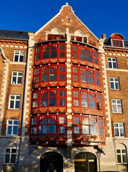 Ein wunderschönes historisches Gebäude mit auffällig rot gestrichenen Erkern und großen Bogenfenstern in der Mitte