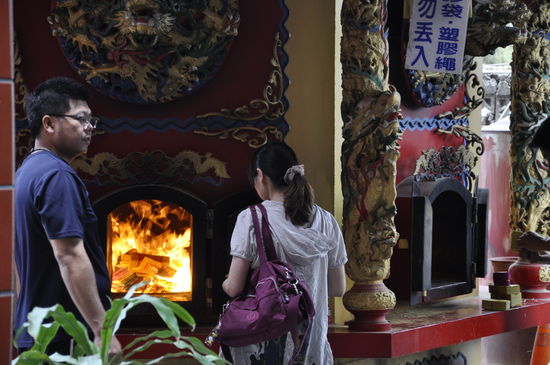 Hier werden dauernd dicke Bündel von bunten Papierblättern verbrannt