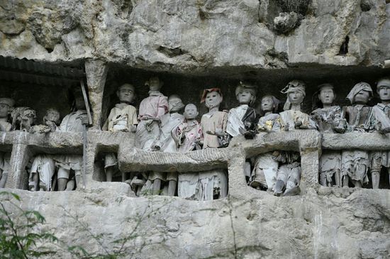 Vor den Gräbern stehen die traditionellen Tao-Tao Puppen aus Holz.