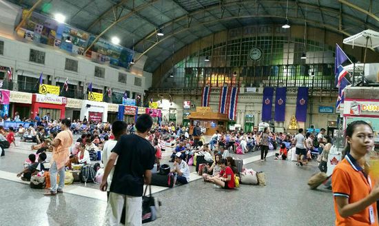 Der Bahnhof in Bangkok, viele sitzen,essen  oder schlafen hier auf dem Boden