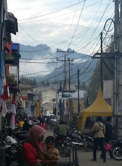 Ein typisches Bild von der Stadt Berastagi mit den schwelenden Vulkanen im Hintergrund. Das ist auch eigentlich ein Fußweg, aber vollgestopft mit Motorbikes