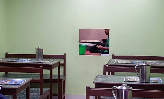 Im hinteren Bereich ist ein Loch in der Wand zur Küche. Man kann beobachten wie die MoMos zubereitet werden.