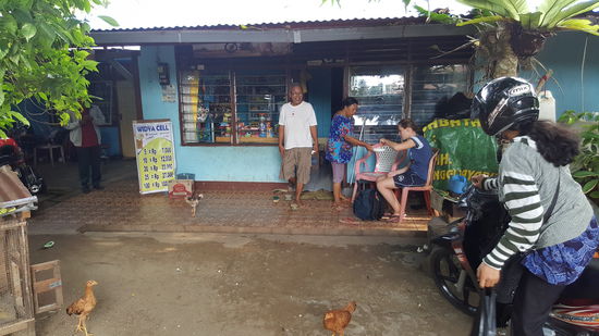 Mama schält uns Mangos. Die Hühner die da rumlaufen, sind megaschlank...