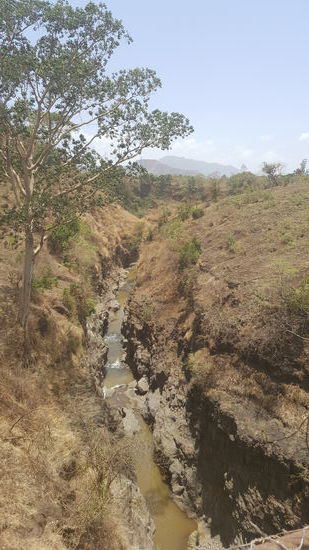 Das Flussbett zur anderen Seite von der wackligen Hängebrücke fotografiert.