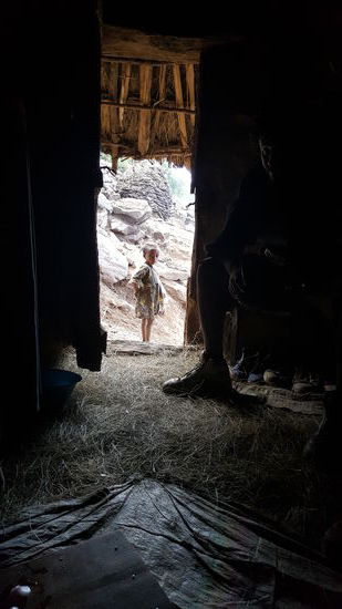 Kinder schauen vorsichtig in die Hütte...