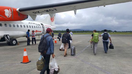 Ich schätze, so 80 Passagiere steigen in die kleine Propellermaschine ein...