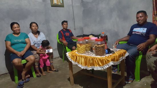 So sieht hier die "Gute Stube" aus. Möbel gibt es nicht. Nur einen Tisch mit dieser bunten Synthetiktischdecke...Kekse und als Getränk Palmwein mit Bier gemischt...