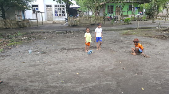Diese Kinder spielen mit Murmeln im Sand wie wir es von früher kennen.....
