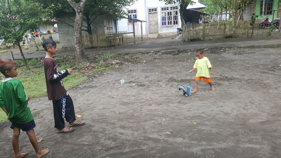 Der eine kleine Junge hat ein Auto am Stock mit Bindfaden...es ist wie in einem alten Film...