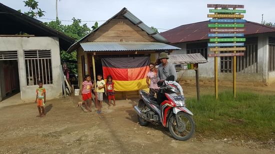 Wir fahren noch mal kurz zur „Tankstelle“ hier hängt auch wie in vielen Hütten eine Deutschlandfahne und man eilt um mich zu „besichtigen“