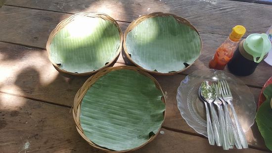 Als Teller dienen immer diese Körbchen mit frischen Bananenblättern