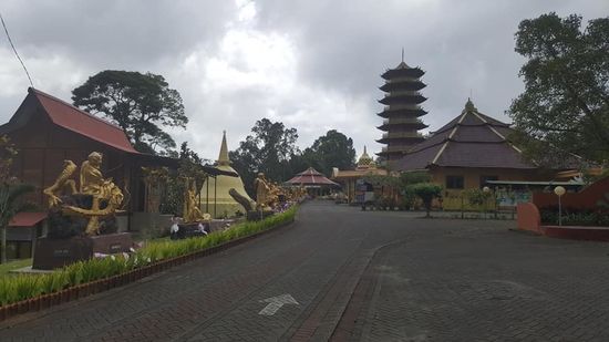 Links des Weges zum Tempel säumen goldene Statuen