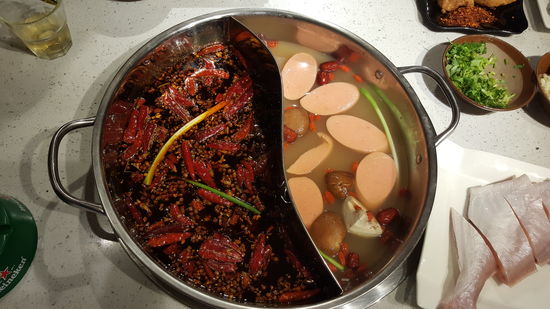 Der Mann rät uns einen geteilten Pot zu nehmen, mit einer scharfen und einer milden Seite. Die scharfe Seite können wir garnicht nehmen. Einiges schwimmt schon drin: Gemüse, Pilze, Pepperoni und Wurstscheiben.
Als Fisch bekommen wir einen kleinen Fisch im Ganzen serviert.