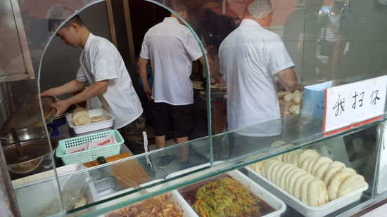 Anschließend entdecken wir wieder etwas neues zum essen: gefüllte Brottaschen, die hier zusammengestellt werden.
Aber man muss vorher zu einer Kasse gehen und bestellen , was man möchte und hier dann nur den Bon abgeben
