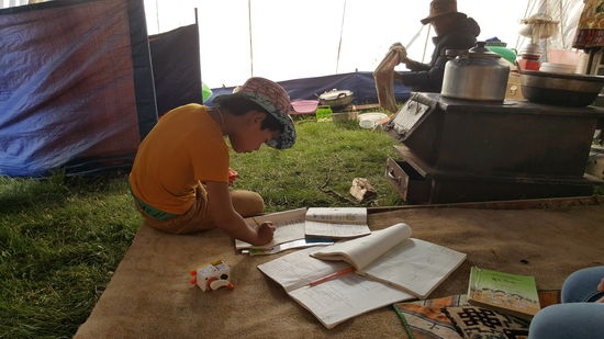 Die Jungs müssen Hausaufgaben machen. Ich denke fast es sind Zwillinge—sie haben diesselben Schulbücher. Hinten links ist übrigens das Depot für den Yak-Dung zum Heizen