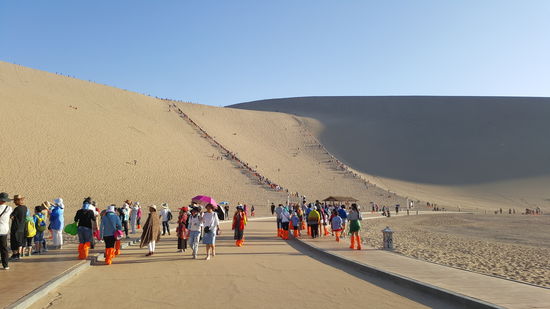 Wie die Ameisen krabbeln alle die Dünen hinauf
