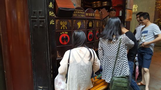 Eine Art Kino. Die Leute, nicht nur kids- schauen durch die Löcher und der Mann rechts erzählt die Geschichte...