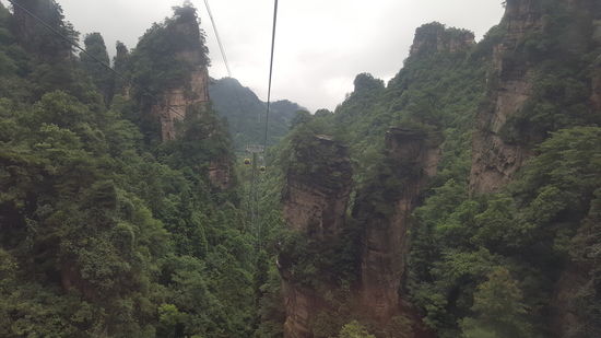 Die Seilbahn fährt uns zwischen den steilen Bergen hinauf, wir sind begeistert von dem Anblick der steilen Felsen
